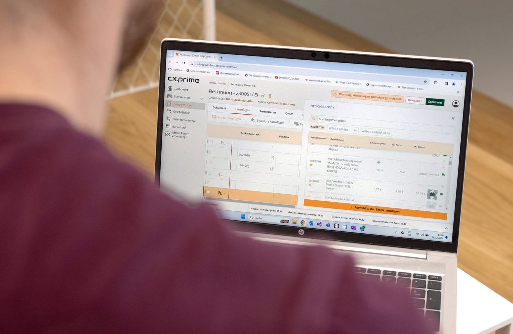 Rechnungsprogramm für Elektriker – Einfach, schnell und gesetzeskonform 1 Mitarbeiter vor einem Laptop-Screen mit Rechnungsprogramm für Elektriker