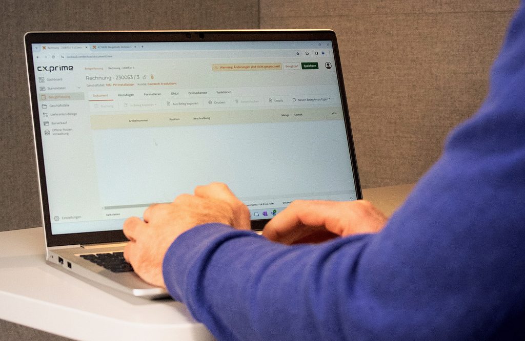 Mitarbeiter an einem Laptop am Arbeiten mit einem Rechnungsprogramm für Installateure